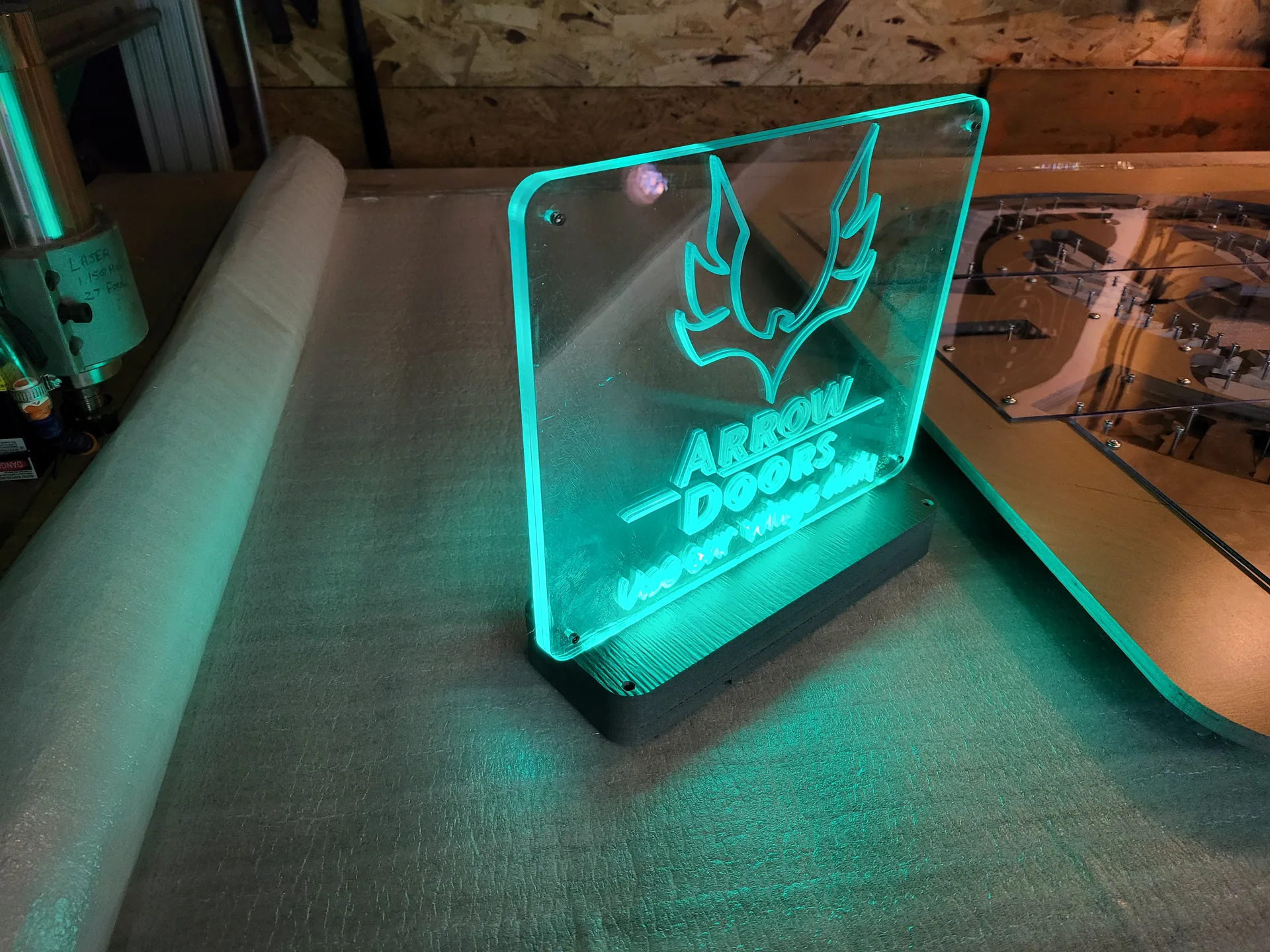 Edge lit acrylic sign Arrow Doors teal