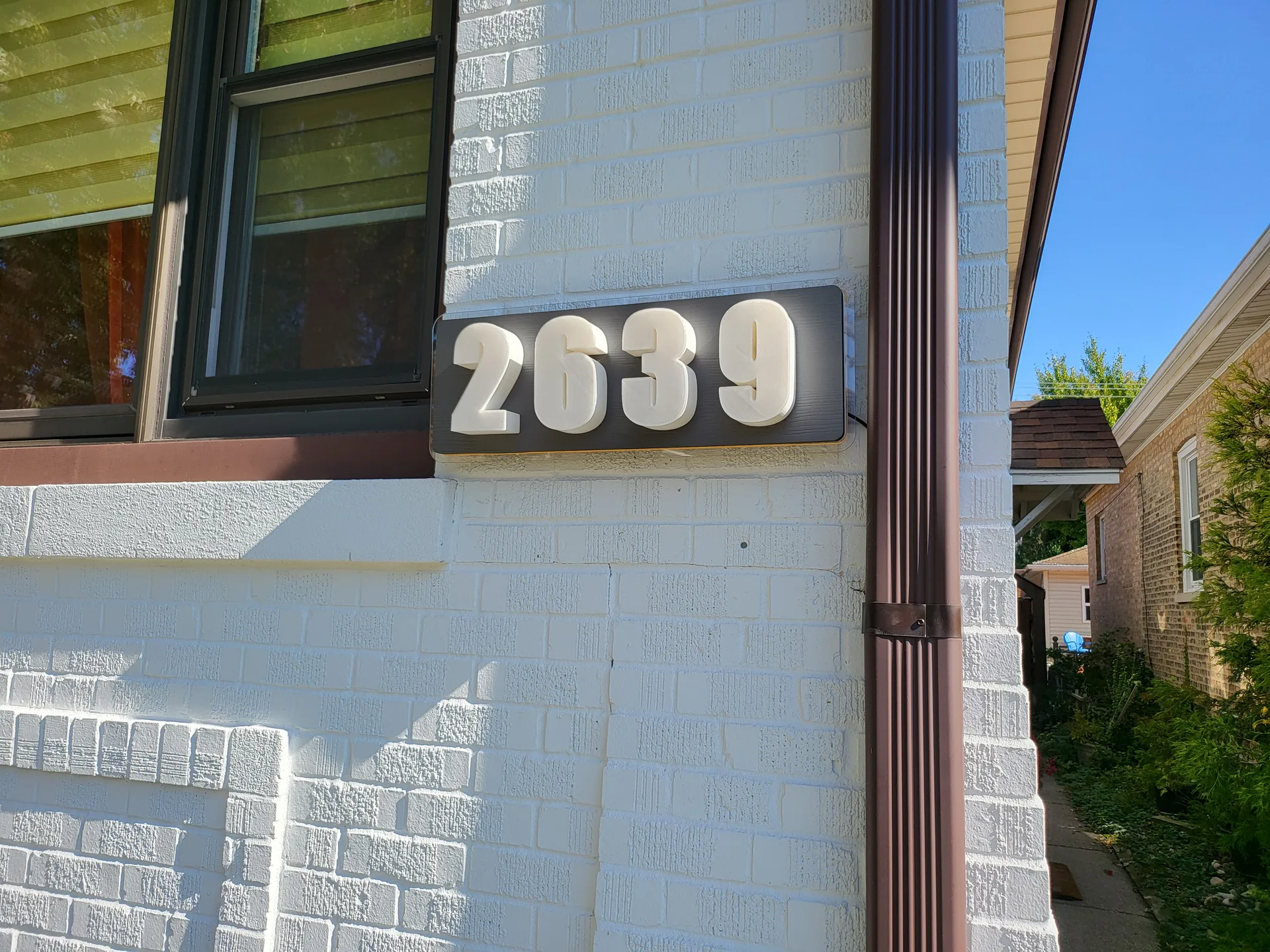 Modern house numbers installed brick facade